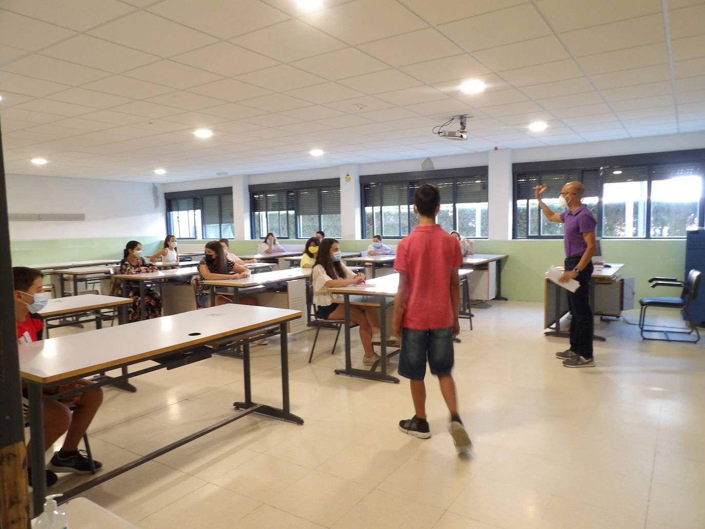 El profesor indica a los alumnos dónde deben sentarse 