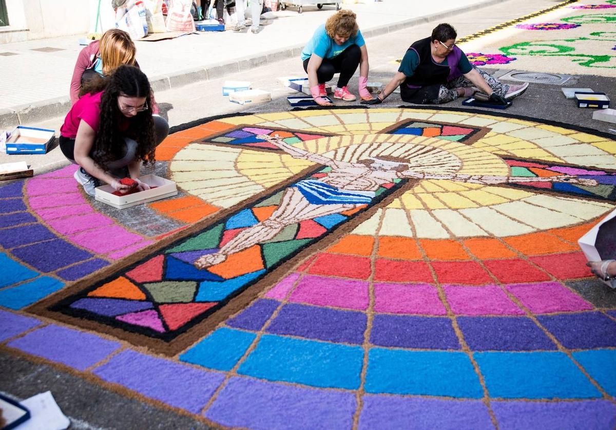 Vecinas de la calle larga ultiman los detalles del tapiz.