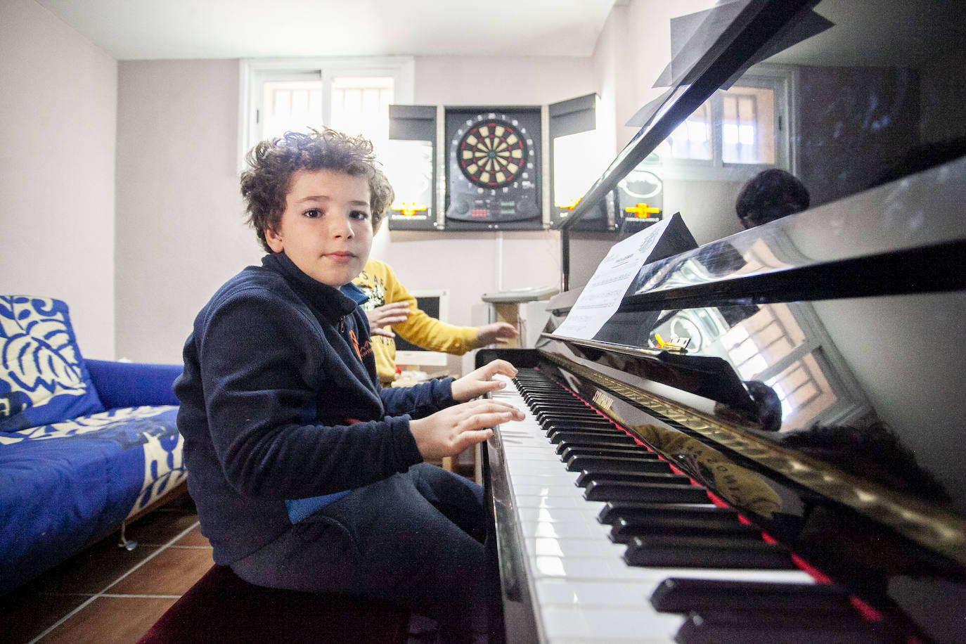 Hugo tocando el piano en su casa. 