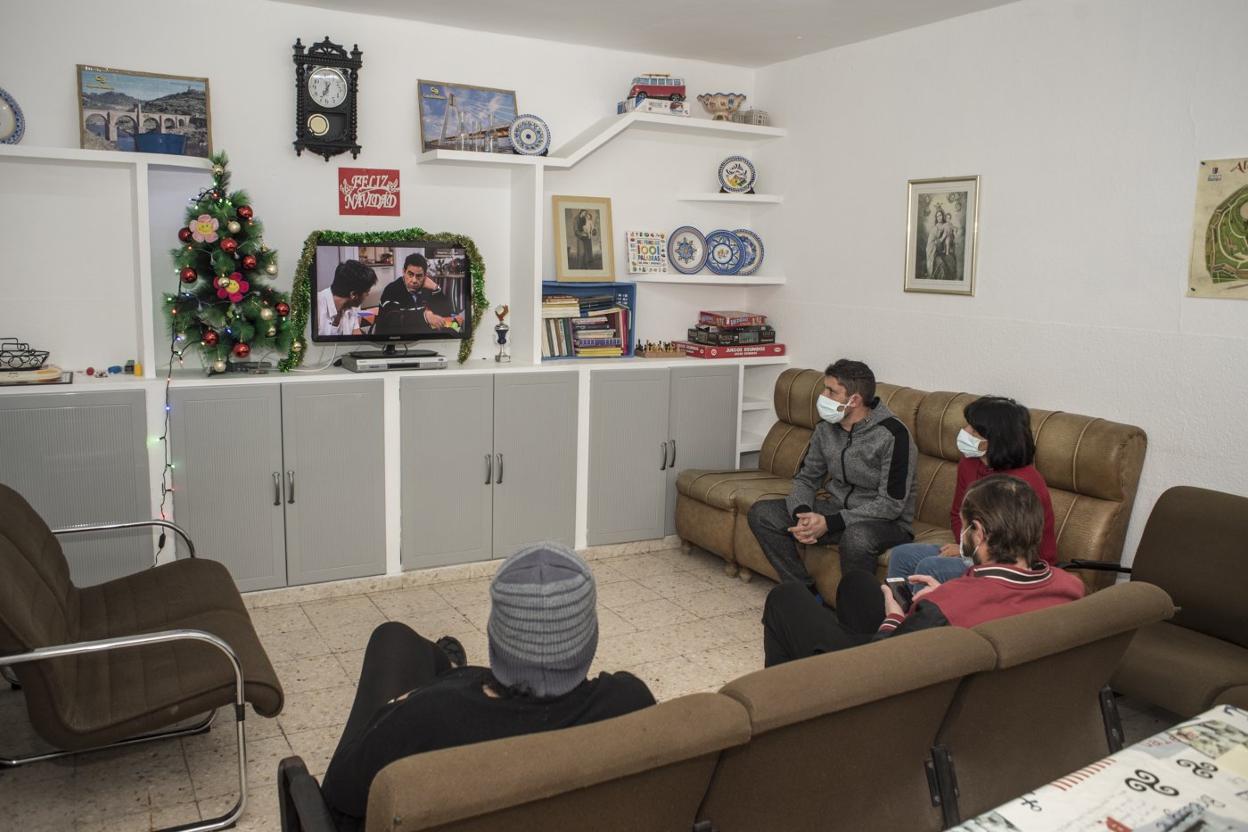 Varias personas ven ayer, día de Navidad, la televisión en el albergue de Bravo Murillo. 