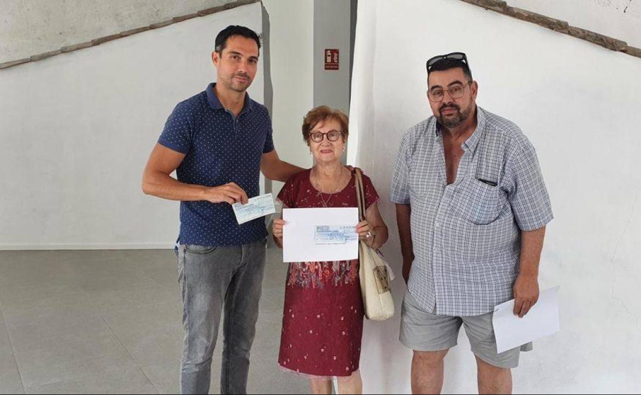 Isabel y Santiago entregan el cheque al alcalde, Manolo Borrego. 