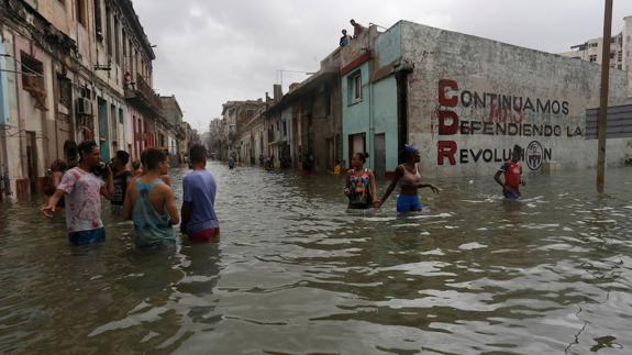Vecinos caminan por un barrio inundado de La Habana tras el huracán Irma.