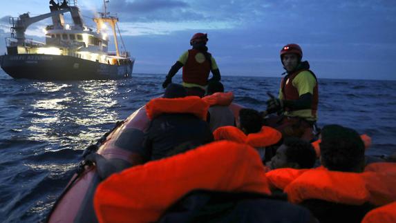 Socorristas de la ONG Proactiva Open Arms rescatan inmigrantes de una patera de madera abarrotada que navegaba a la deriva.