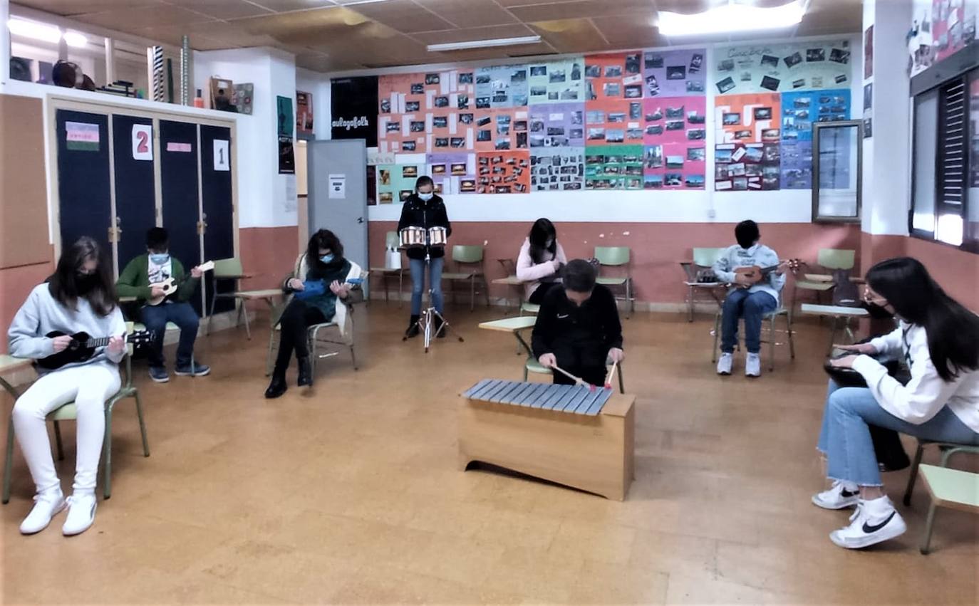 Estudiantes en la clase de música y a la espera del cambio para que suene un tema. 