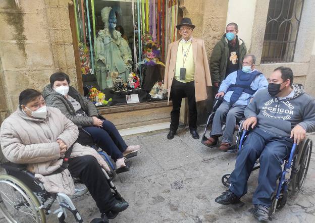 nrique Elías con usuarios de Aspace Cáceres, junto al escaparate. 