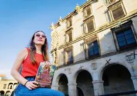 Carmen Sánchez-Risco con su libro ante el palacio de Trujillo que levantó Francisca Pizarro.