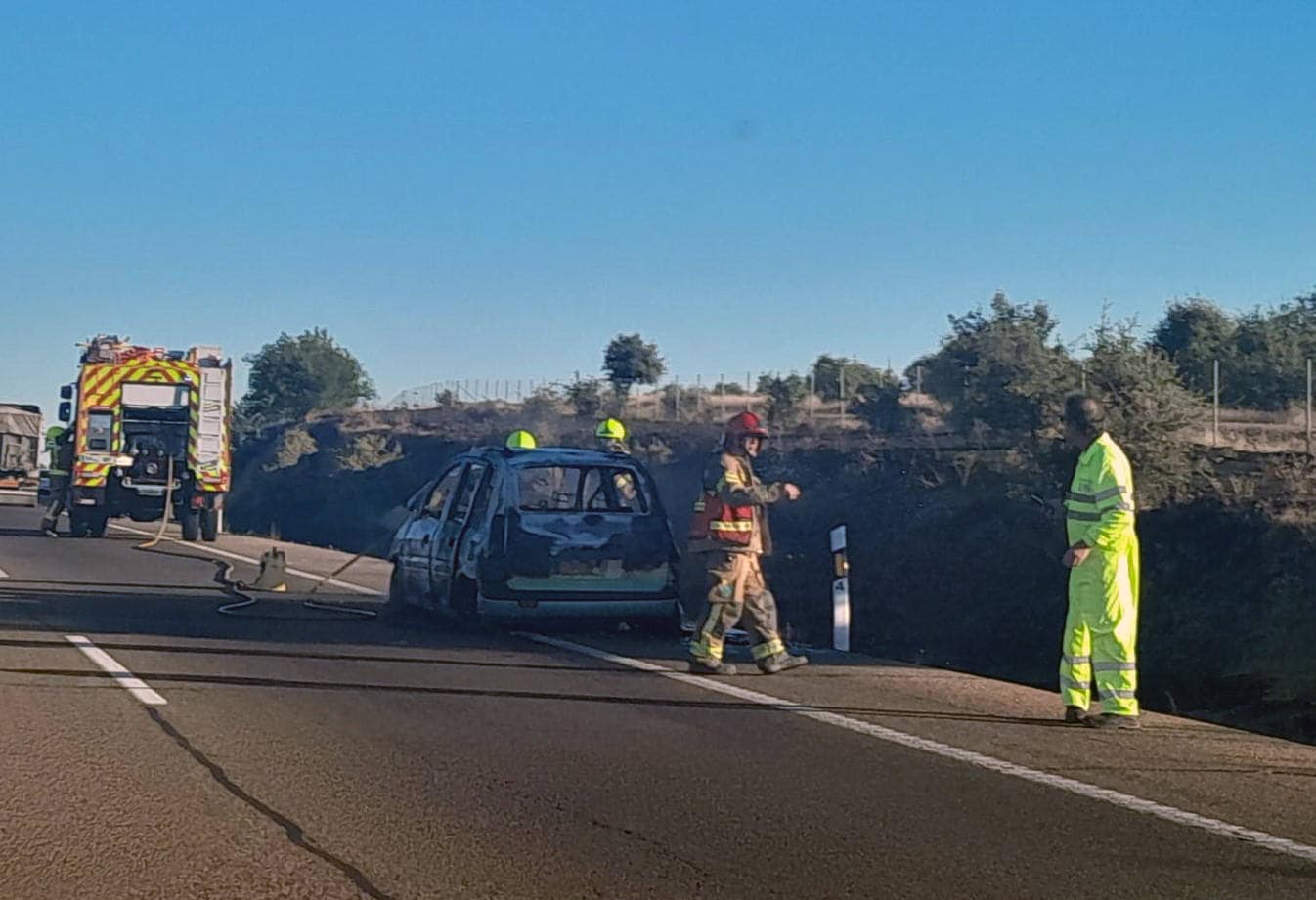 El vehículo afectado, con los bomberos.