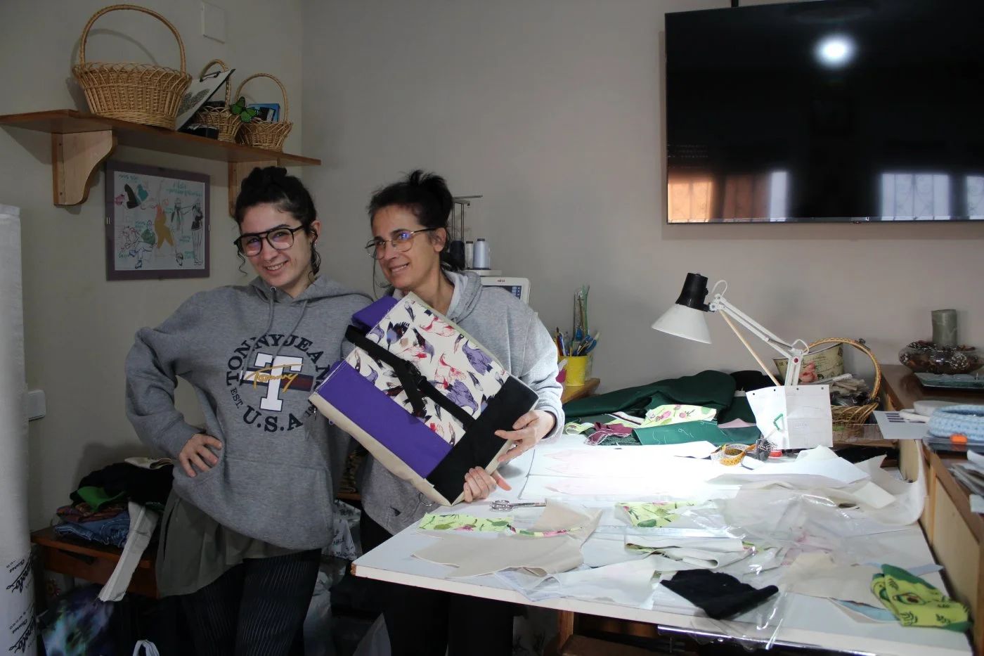 Hija y madre en el taller de costura con alguna de sus creaciones.