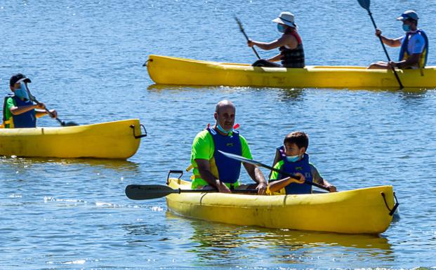 Imagen principal - Arriba: Mayores y pequeños disfrutaron de las piraguas. Abajo izquierda: Preparándose para comenzar la actividad. Abajo derecha: Escuchando las indicaciones de los monitores