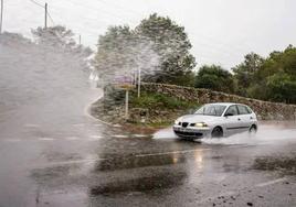 Foto de archivo de un coche circulando con fuertes lluvias