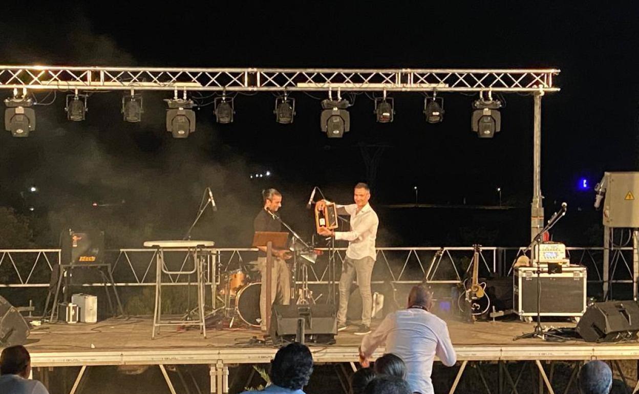 Alberto Carrillo, pregonero, recibe un obsequio de la mano del presidente de la asociación de vecinos 'Las Peñitas'