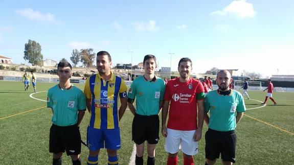 colegiado, sus asistentes y los capitanes de ambos equipos posan en los prolegómenos del partido. 