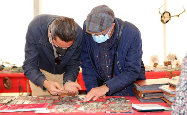 Dos coleccionistas se interesan por las monedas. 