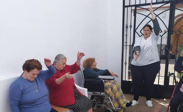 La supervisora Almudena Alcántara da gimnasia terapéutica en el recinto exterior.