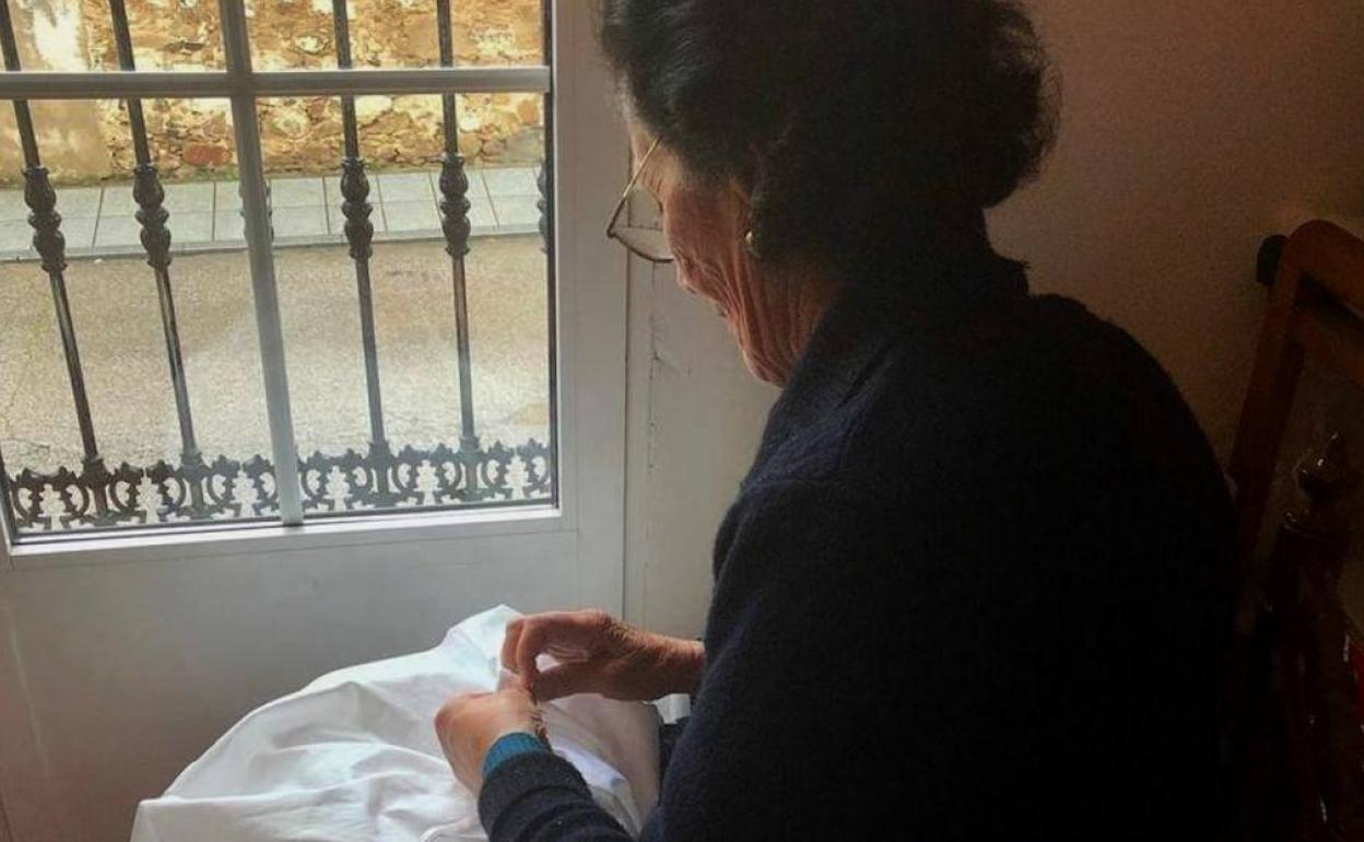 Ángela Boyero, a sus 84 años, cosiendo una bata