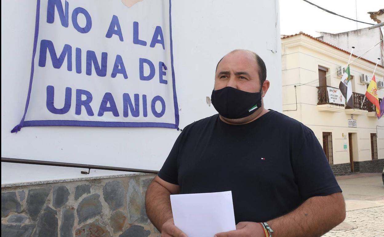 Gregorio Gallego, alcalde de Zahínos, junto a uno de los numerosos carteles que se ven en el municipio de la Sierra Suroeste. 