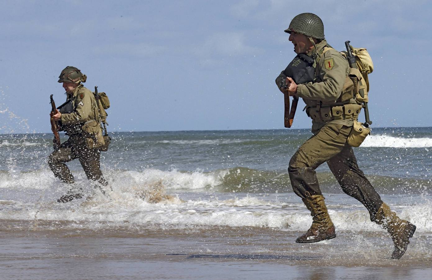 Entusiastas de la historia visten uniformes militares estadounidenses de la Segunda Guerra Mundial en la playa de Omaha en Viervill-sur-Mer. REUTERS / Pascal Rossignol.