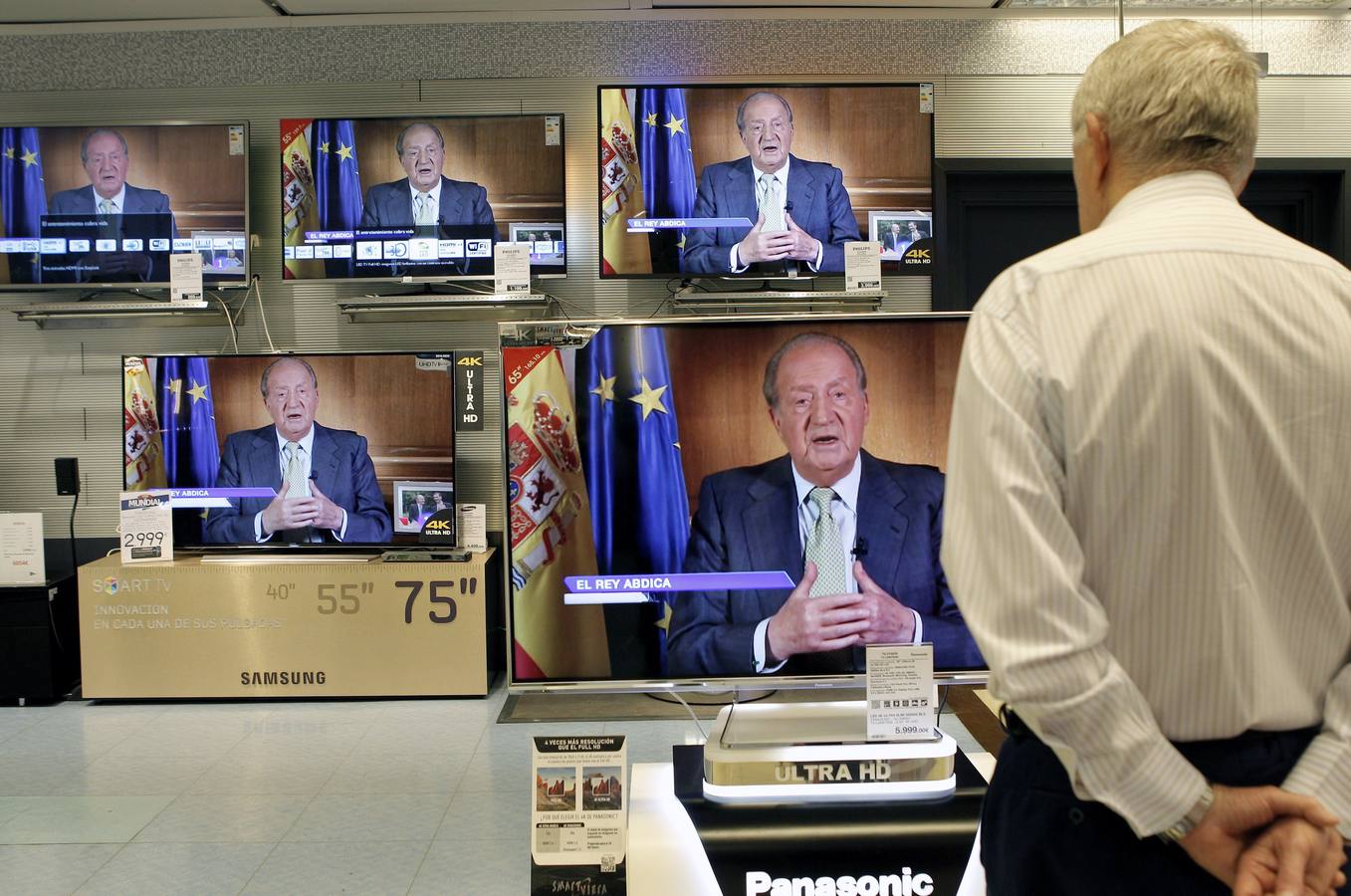 Lunes, 2 de junio. Varias personas siguen desde las televisiones de unos granes almacenes la intervención del Rey en la que ha anunciado su abdicación en favor de su hijo el Principe Felipe. EFE/ Juan Carlos Cárdenas