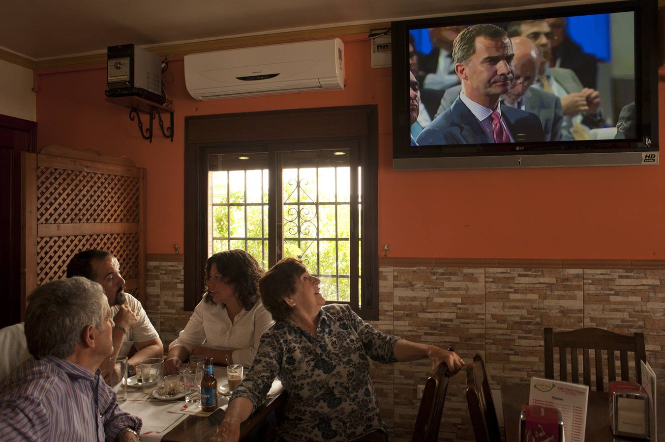 Lunes, 2 de junio. Los clientes de un bar de Ronda miran la televisión en la que se transmiten imágenes de archivo del príncipe Felipe tras la abdicación del rey Juan Carlos. AFP PHOTO / JORGE GUERRERO