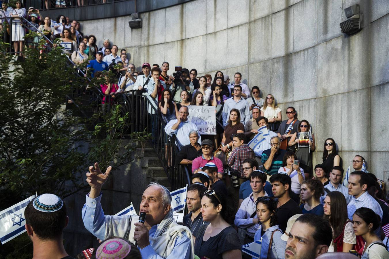 Martes, 1 de julio. El Rabino Avi Weiss habla en medio de los manifestantes durante una ceremonia en memoria de los tres adolescentes israelíes desaparecidos cuyos cuerpos fueron encontrados en la ocupada Cisjordania, cerca de la sede de las Naciones Unidas. Varios cientos de personas ondeando banderas israelíes y expresando dolor y solidaridad realizaron una vigilia en Nueva York después de que los cuerpos de Eyal Yifrach, 19, Gilad Shaar, 16 y Naftali Fraenkel, 16, fueran encontrados en un campo cerca de Hebrón, no lejos de un camino en el que se creía que habían sido secuestrados mientras hacían autostop el 12 de junio. REUTERS / Lucas Jackson