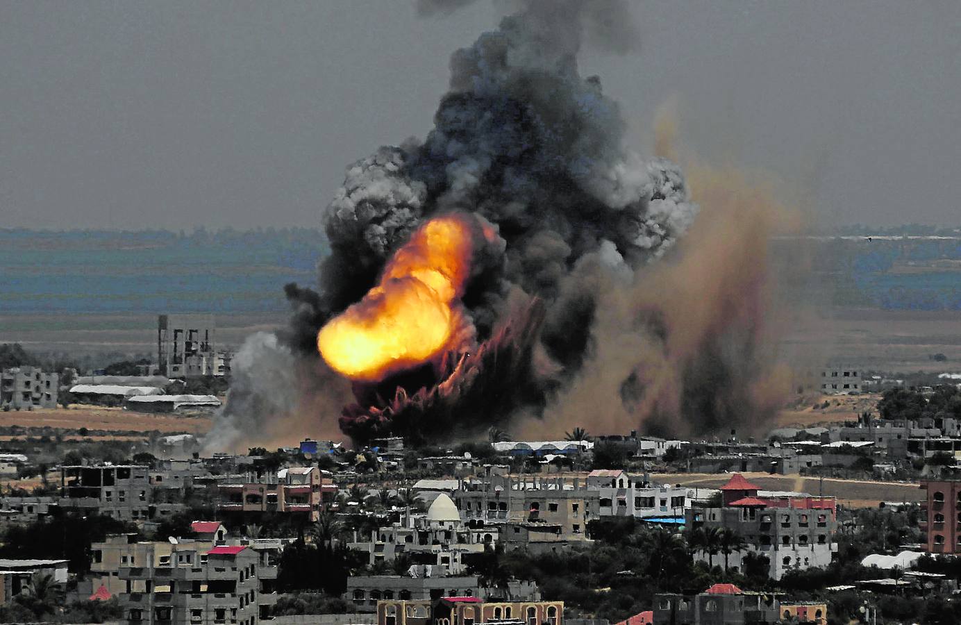 Lunes, 7 de julio. Humo y llamas después del bombardeo israelí a una docena de objetivos en la Franja de Gaza. Estos bombardeos se intensificaron después de los ataques palestinos con cohetes contra ciudades israelíes. REUTERS / Ibraheem Abu Mustafa