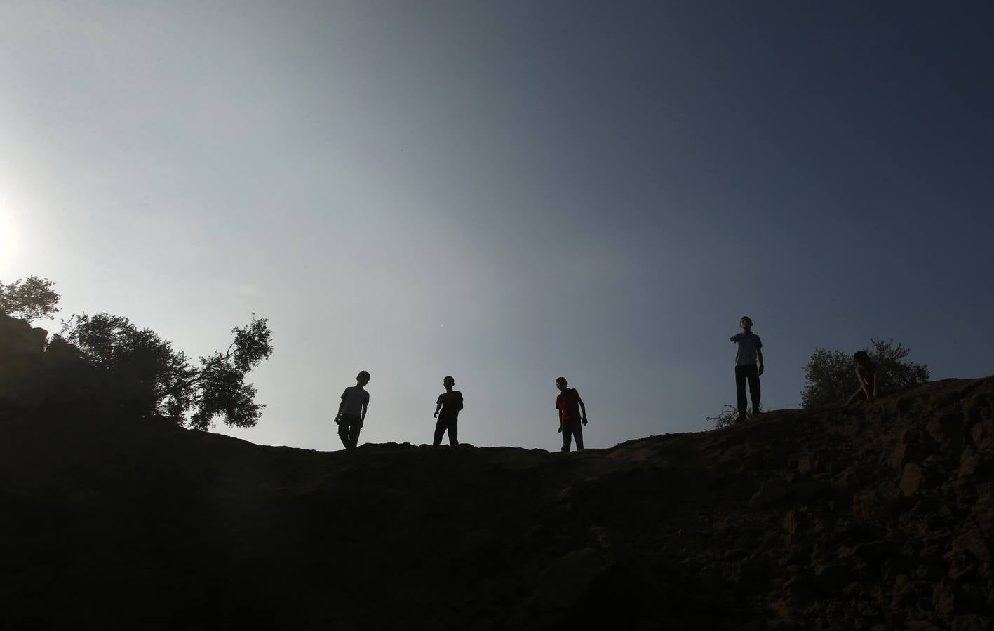Lunes, 7 de julio. Niños palestinos miran el cráter causado por uno de los múltiples ataques aéreos realizado por la aviación israelí contra Gaza. REUTERS / Mohammed Salem