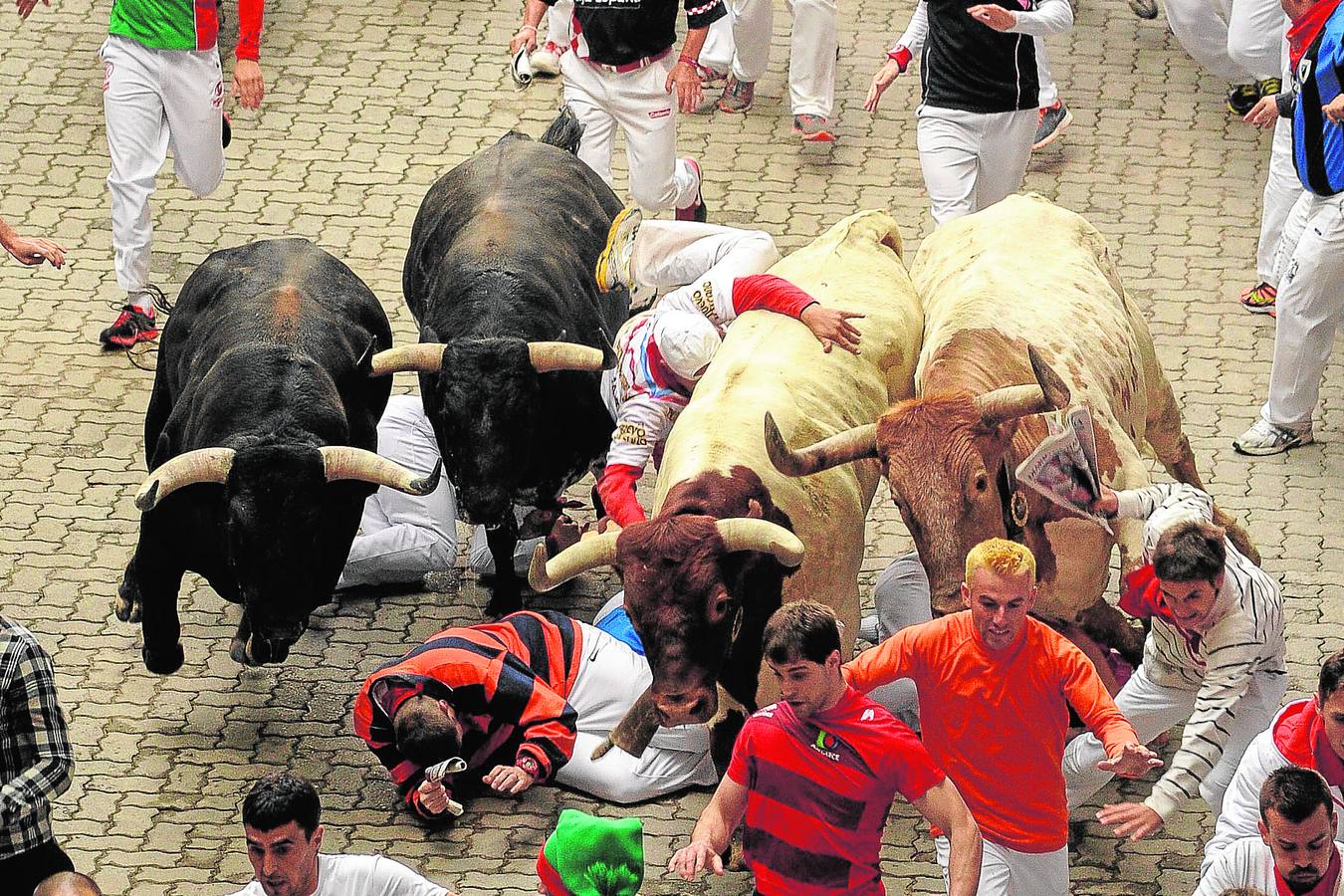 Jueves, 10 de julio. Corredores delante de los toros de la ganadería de Garcigrande durante el cuarto encierro de los Sanfermines AFP PHOTO / PEDRO ARMESTRE