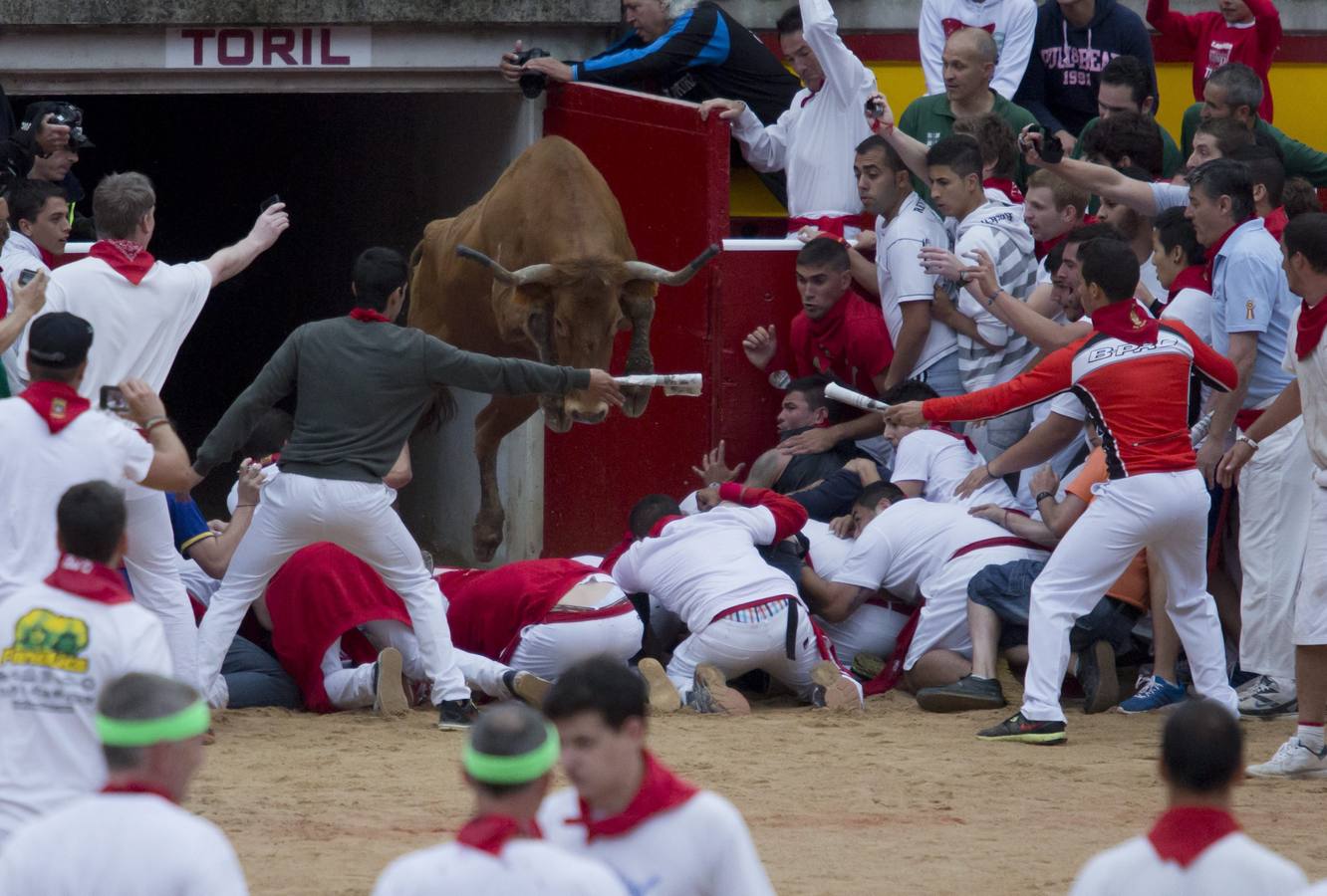 Jueves, 10 de julio. Un grupo de mozos se agolpa en la entrada de toriles mientras una vaquilla salta por encima de ellos después del encierro con toros de la ganadería de Victoriano del Río en los Sanfermines en Pamplona (Navarra). EFE/Jim Hollander