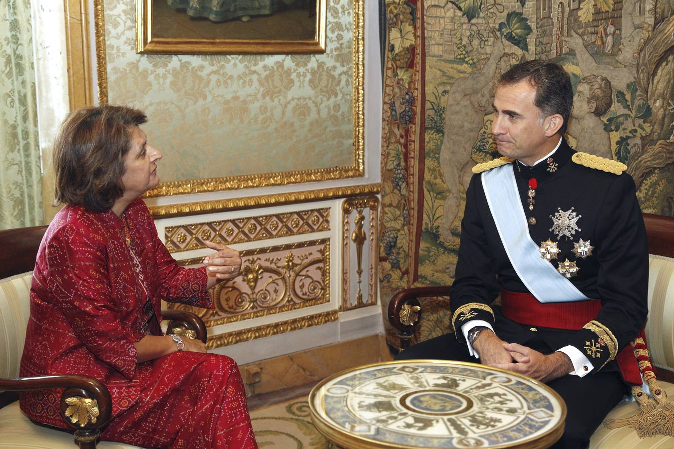 El Rey Felipe VI conversa con la embajadora de Uganda, Nimisha Jayant Madhvani (i)