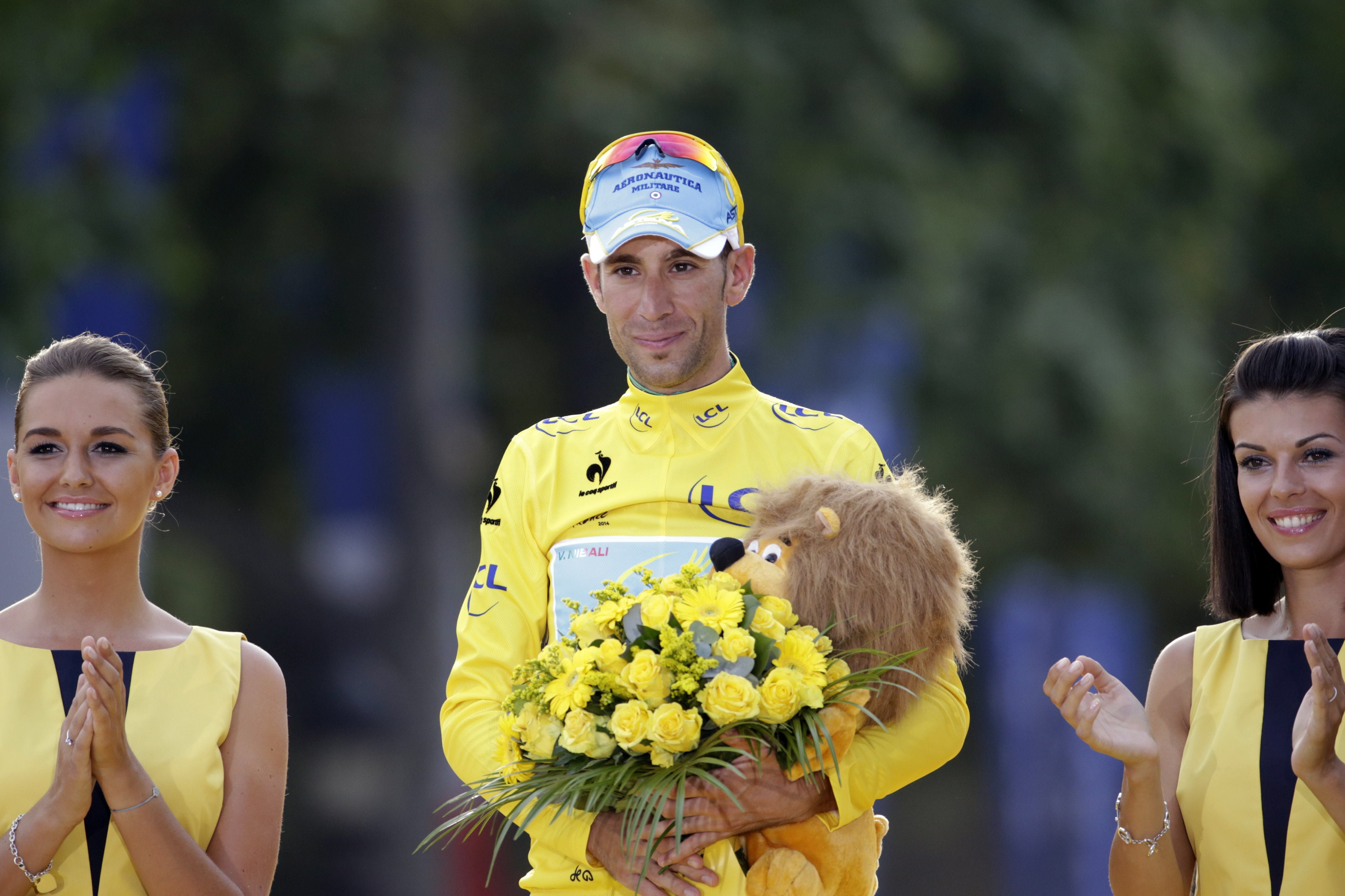 Nibali, con su maillot amarillo y los regalos del Tour, en el podio final de la ronda francesa.