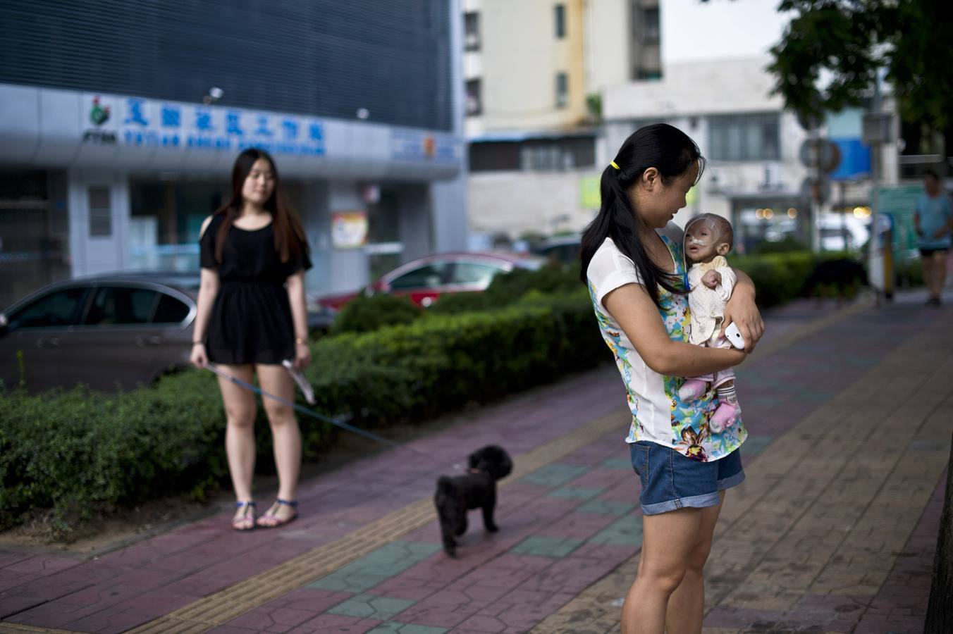 Lunes 1 de septiembre: Wu Lunjiao sostiene a su hija Yuanyuan, que sufre de una enfermedad desconocida, en Shenzhen, provincia de Guangdong. Yuanyuan, que pesa 2,5 kg solo ha aumentado 0,05 kg desde que nació hace 13 meses. A pesar de que la familia ya ha pagado 12,400 euros para conseguir un informe médico de los hospitales de Shenzhen, Guangzhou y Beijin que indique el mal que aqueja a la niña, pero aún se desconoce la enfermedad. REUTERS / Stringer