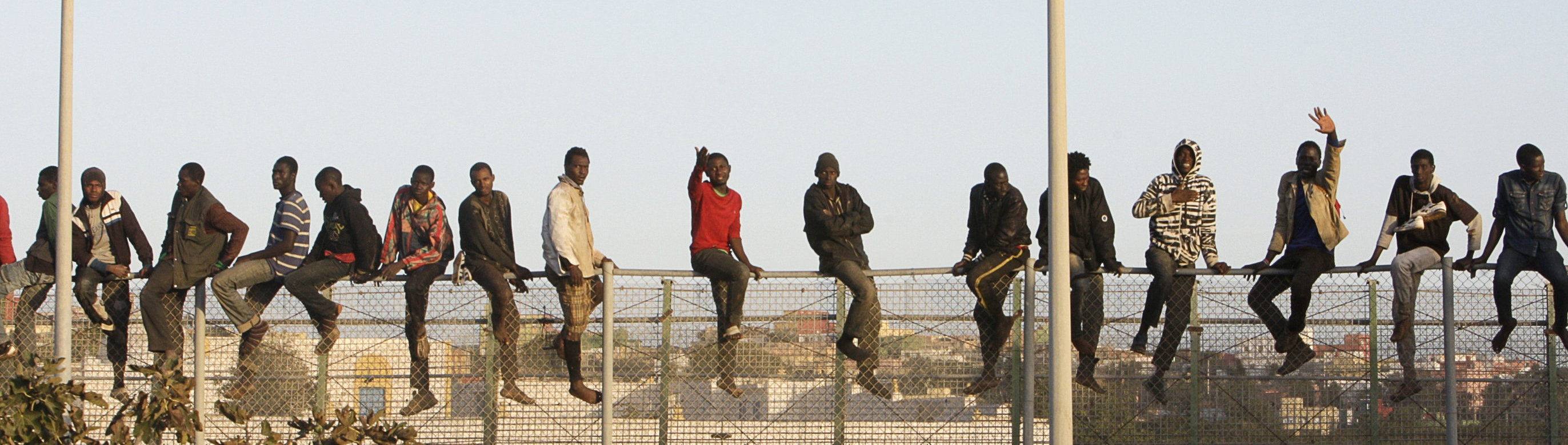 Decenas de inmigrantes encaramados en la valla fronteriza de Melilla