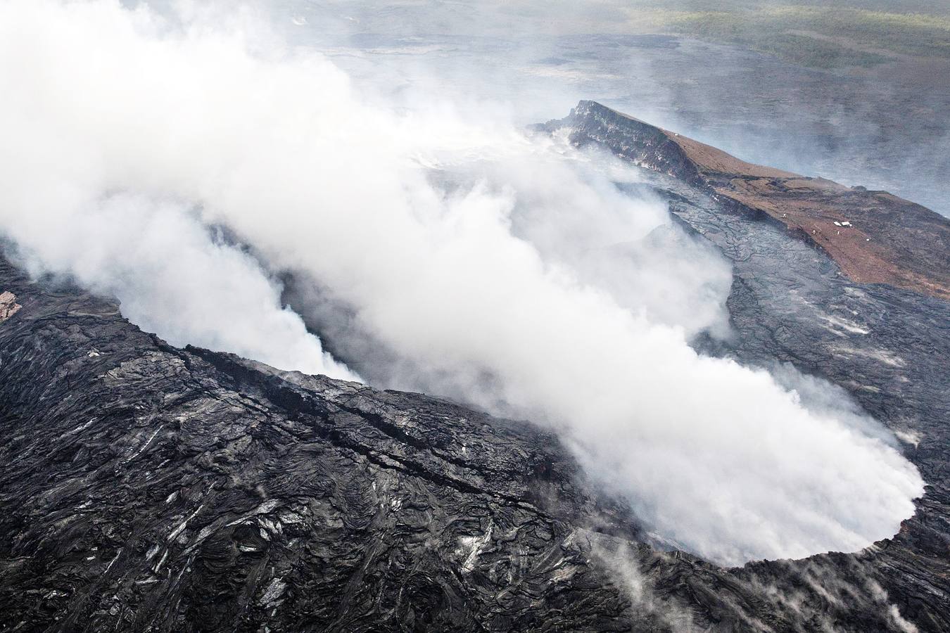 Jueves, 30 de octubre: Tras la erupción del volcán Kalauea, en Hawai, algunos operarios tratan de desviar la lava que baja por la ladera para evitar que arrase la aldea Pahoa. Un río de lava fundida se desplaza lentamente por las zonas agrícolas y residenciales de Isla Grande desde hace semanas arrasando todo aquello que encuentra a su paso. Fotografías: REUTERS/EFE