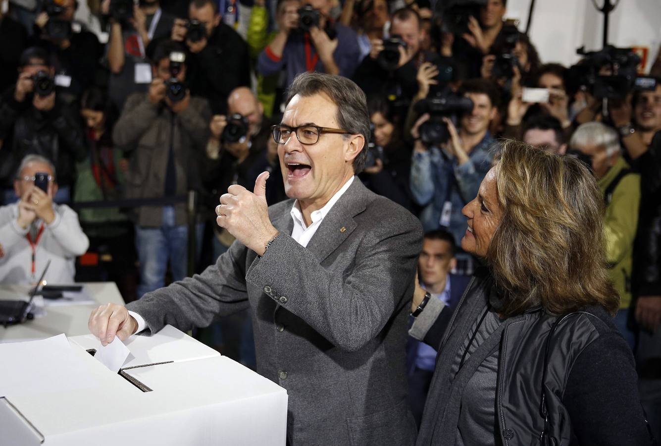 Artur Mas hace la señal de la victoria en el momento de depositar su papeleta.