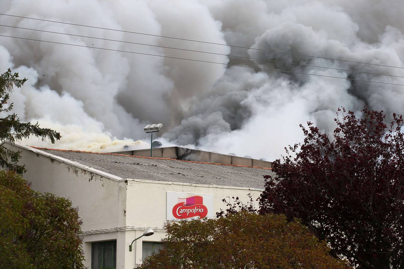 Domingo, 16 de noviembre: Vista del humo del incendio que causó daños muy graves en la planta principal de la empresa cárnica Campofrío en Burgos, en el polígono industrial de Gamonal-Villayuda. No se produjo ningún herido. El denso humo provocado por las llamas, obligó  cortar la ronda de circunvalación de la capital burgalesa y causando la colisión de dos camiones, por la escasa visibilidad.