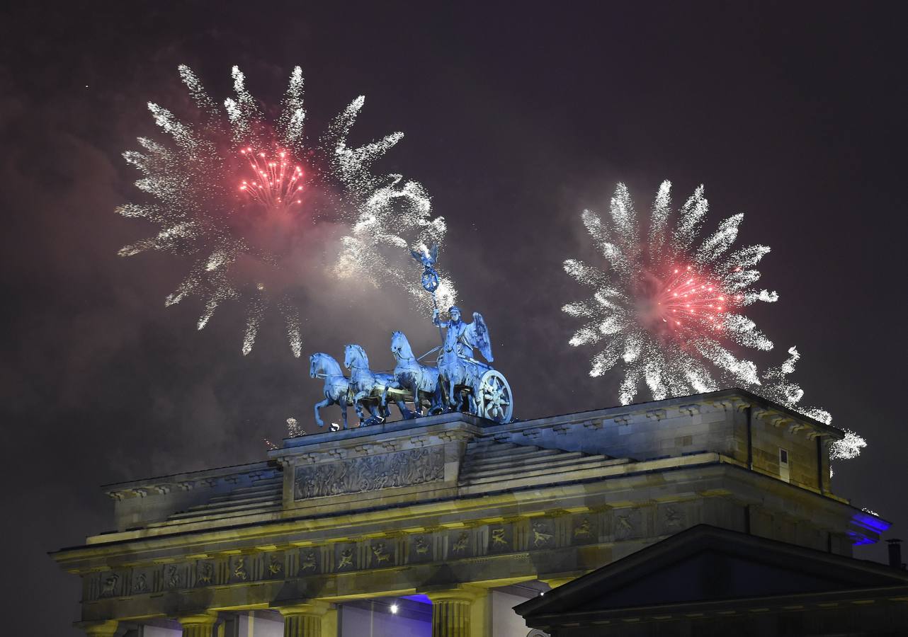 la Puerta de Brandenburgo en Berlín. BERLÍN (ALEMANIA). Fuegos artificiales iluminan el cielo, durante las celebración de Año Nuevo en la Puerta de Brandenburgo en Berlín.