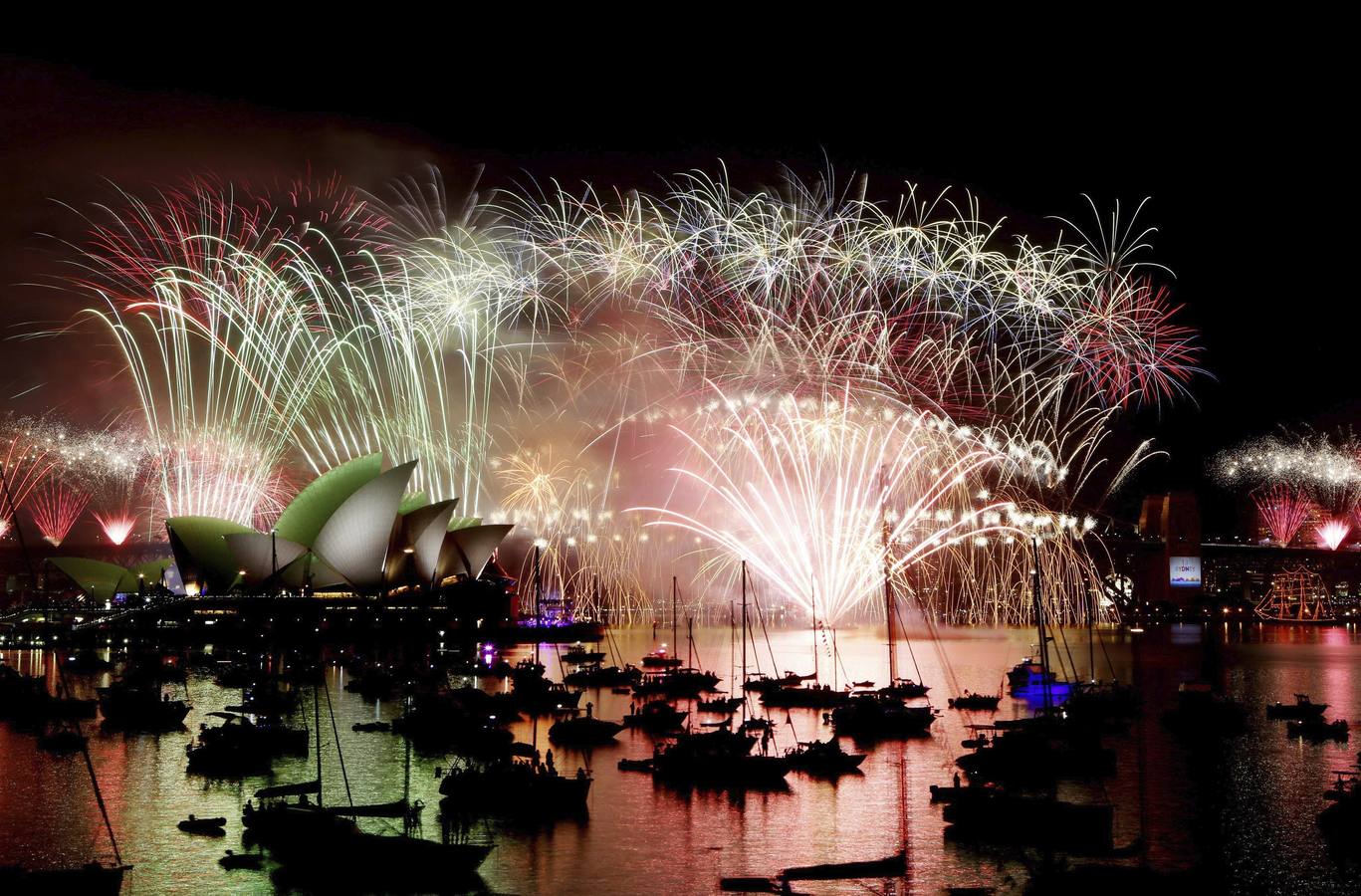 Fuegos artifiales en la Ópera de Sidney. SÍDNEY (AUSTRALIA). Vista del espectáculo de fuegos artificiales sobre el Teatro de la Ópera y el puente Sydney Harbour Bridge para celebrar la llegada del nuevo año en Sídney (Australia).