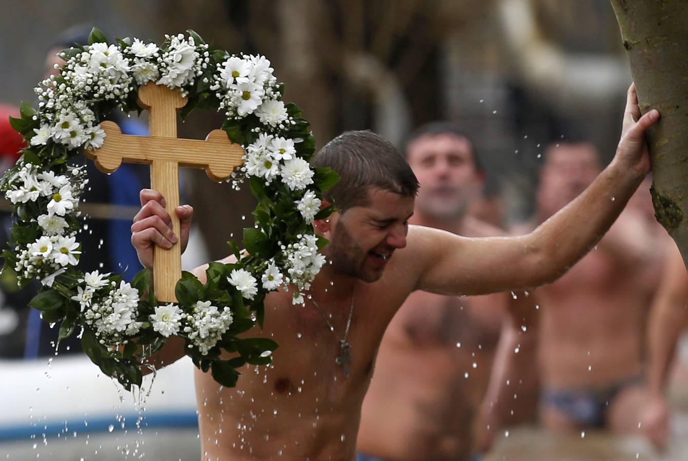 Un hombre sostiene una cruz que ha recuperado del agua durante las celebraciones de la Epifanía en Prijedor, Bosnia y Herzegovina. Los sacerdotes ortodoxos bendicen las aguas lanzando una cruz. Los creyentes intentan recuperarla como si de una competición se tratara ya que según las creencia la captura del símbolo tra salud y prosperidad a quien la atrapa. Fotografía: REUTERS-Dado Ruvić.