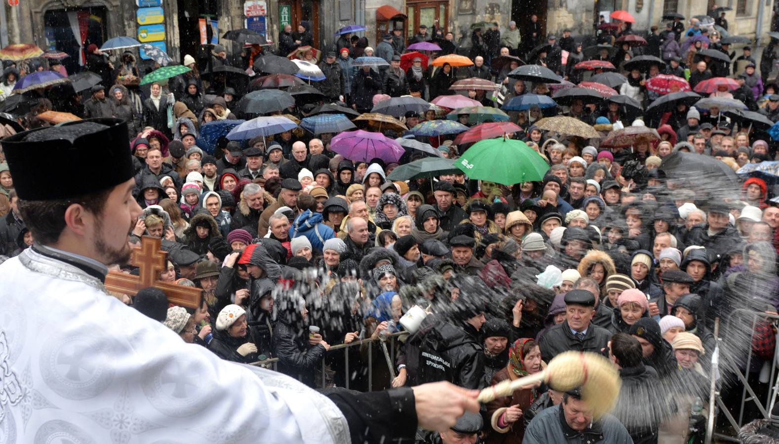Un sacerdote ortodoxo bendice a los creyentes durante la celebración de la festividad de la Epifanía en Lviv, Ucrania occidental. Fotografía: AFP-Yurko Dyachyshyn