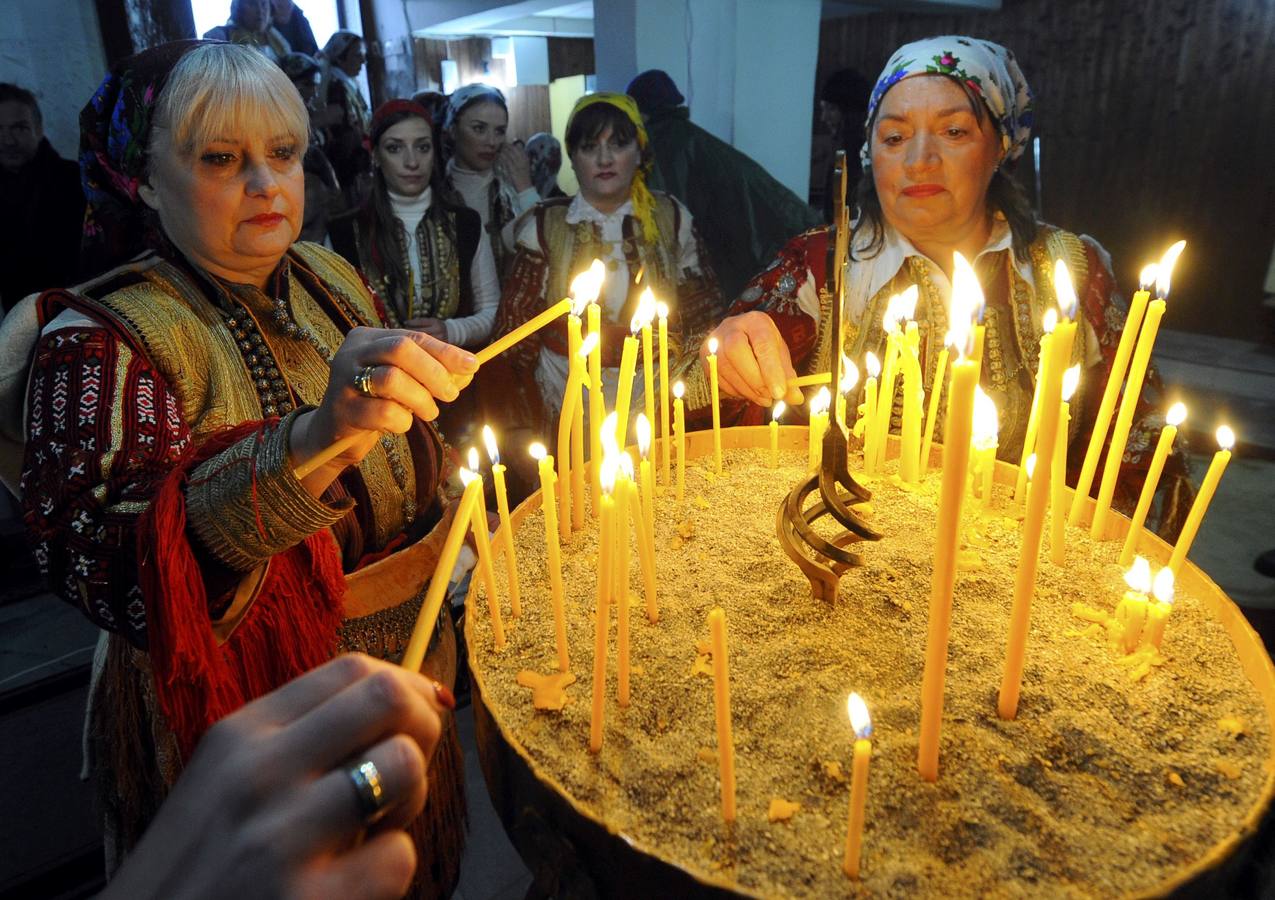 Mujeres vestidas con el traje popular encienden velas durante la celebración del día de la Epifanía en la aldea de Bitushe, a unos 150 kilómetros al oeste de Skopje, Macedonia. Fotografí: REUTERS-Ogenen Teolovski