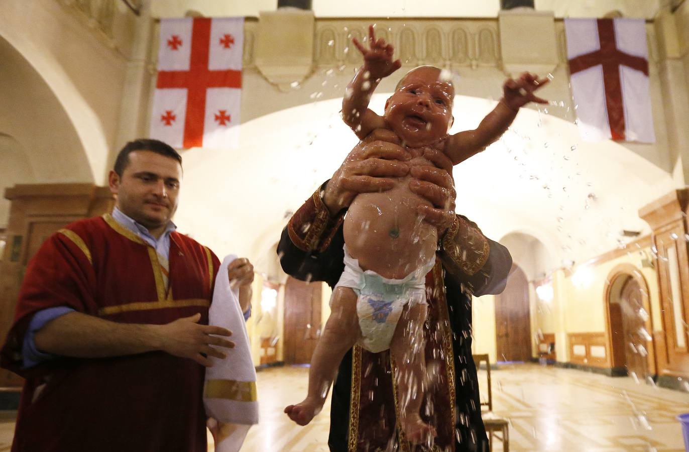 Bebés bautizados durante una ceremonia de bautismo en masa en el día de la Epifanía en Tbilisi. Alrededor de 1.000 niños fueron bautizados por la Iglesia Ortodoxa de Georgia durante la 38ª ceremonia de bautismo en masa en la catedral principal del país. REUTERS / David Mdzinarishvili