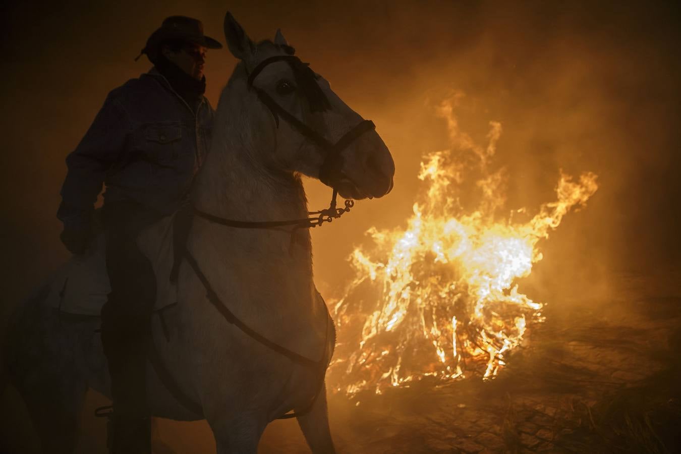 Sábado, 17 de enero: La pequeña localidad abulense de San bartolomé de Pinares volvió a vivir una noche mágica, sumergida bajo una espesa nube de humo que sirvió para purificar al centenar de caballos que pasó por la veintenas de luminarias distribuidadas por las empinadas calles del pueblo. Fotografia: Juan Medina / Reuters