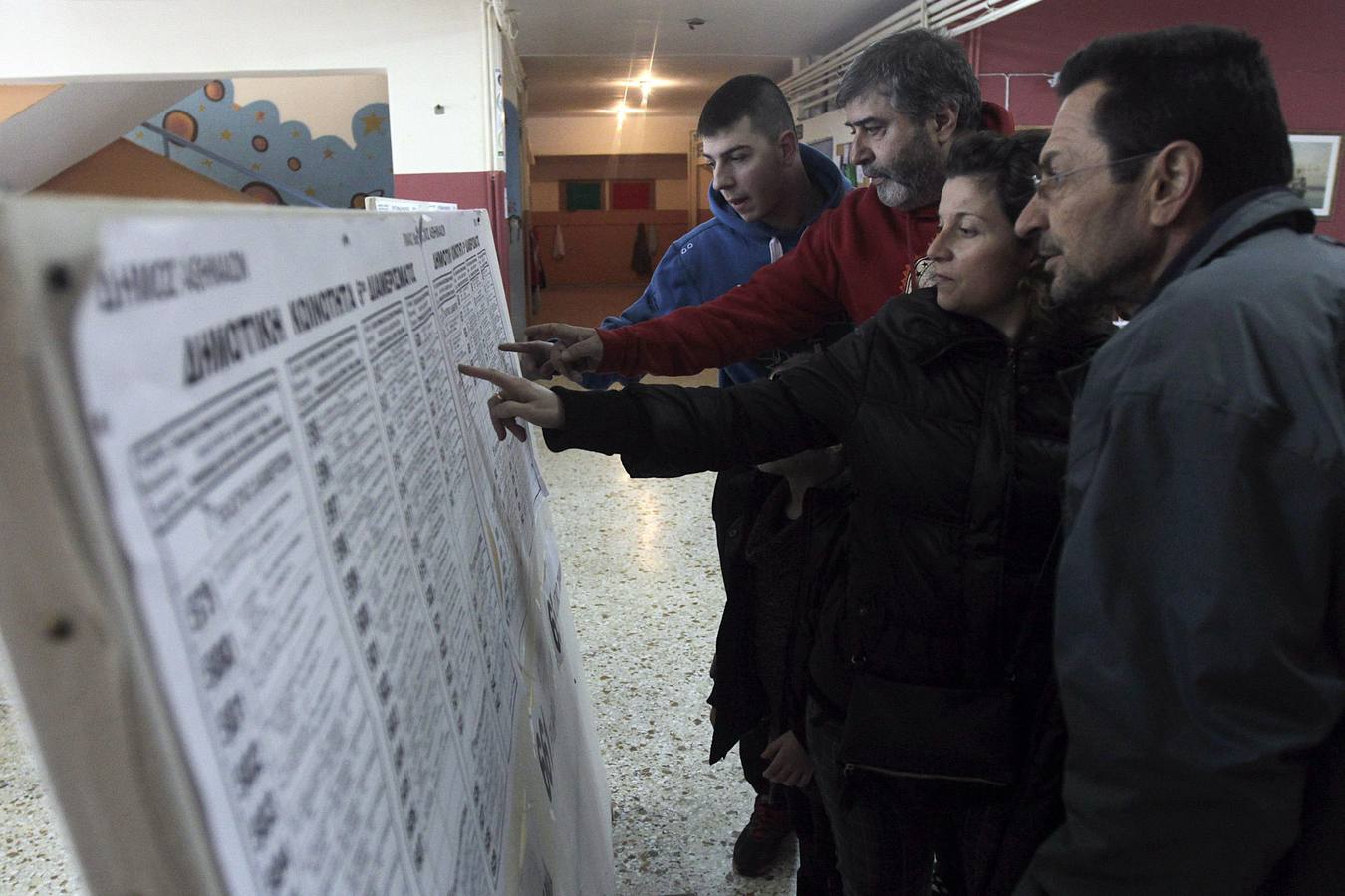 Varios ciudadanos consultan el listado de electores en un colegio electoral en Atenas.