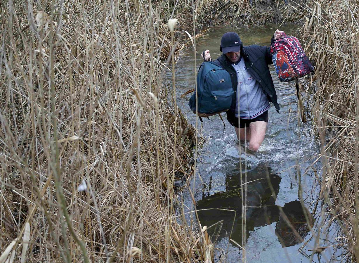 Un hombre de Kosovo lleva a su bebé mientras cruza ilegalmente la frontera entre Hungría y Serbia, cerca del pueblo de Ásotthalom. Fotografía: REUTERS / Lazlo Balogh.