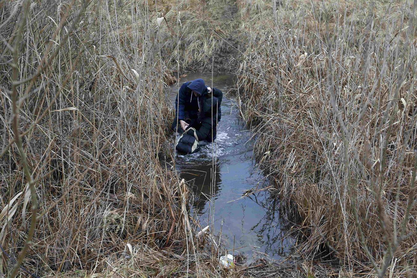 Un hombre de Kosovo lleva a su bebé mientras cruza ilegalmente la frontera entre Hungría y Serbia, cerca del pueblo de Ásotthalom. Fotografía: REUTERS / Lazlo Balogh.