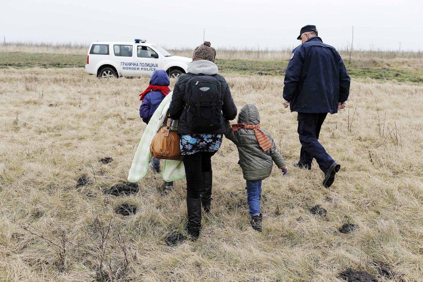 Una mujer kosovar sostiene a su hijo antes de montarse en un vehículo de la policía de fronteras de Serbia tras ser detenidos cerca de la ciudad de Subotica. al tratar de intentar pasar ilegalmente a Hungría. Fotografía: REUTERS / Marko Djurica