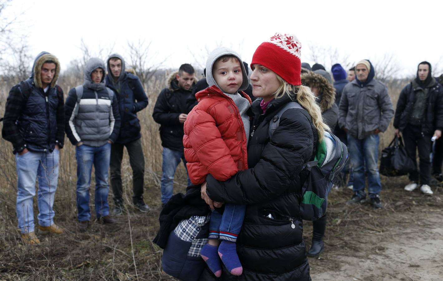 Un policía serbio recoge la documentación de un grupo de habitantes de Kosovo, después de que fueran detenidos cuando trataban de cruzar la frontera hacia Hungría, cerca de la ciudad de Subotica. Fotografía: REUTERS / Marko Djurica