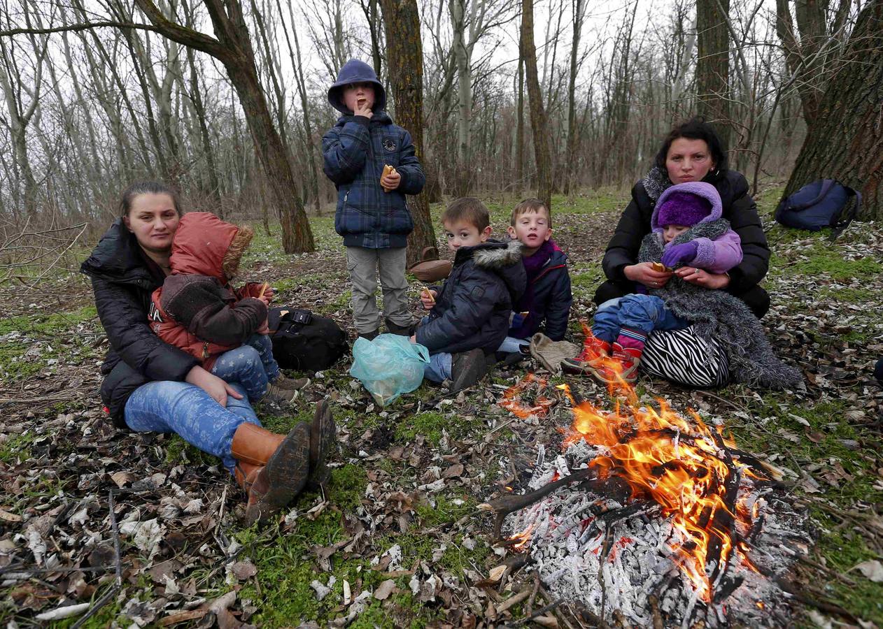 Una familia de kosovares se calienta alrededor de un fuego después de cruzar ilegalmente la frontera entre Serbia y Hungría, cerca del pueblo de Ásotthalom. Fotografía: REUTERS / Lazlo Balogh.