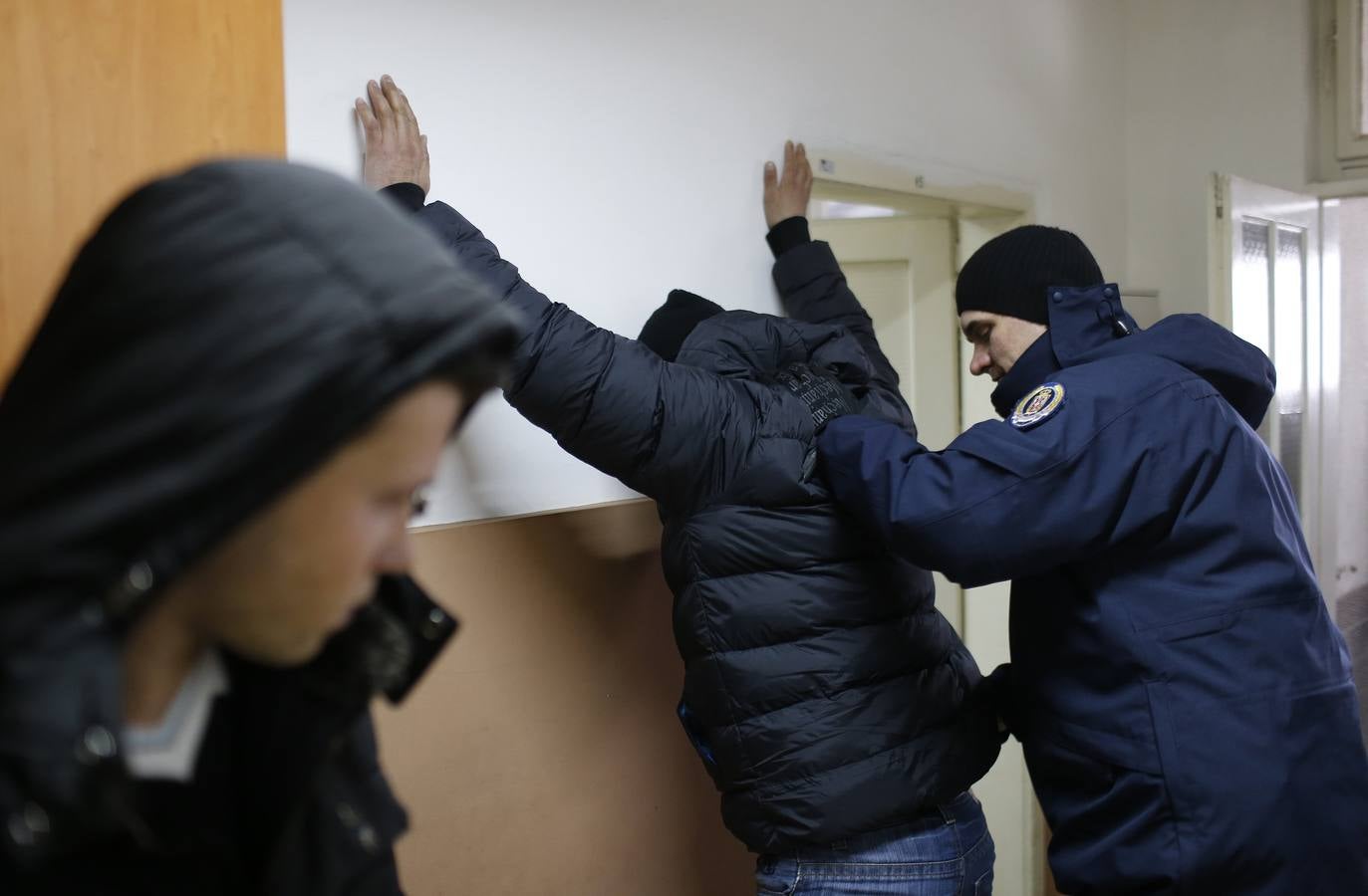 Un grupo de ciudadanos de Kosovo espera en una comisaria de policía después de que fueran detenidos cuando trataban de cruzar la frontera a Hungría, en la ciudad de Subotica. Fotografía: REUTERS / Marko Djurica