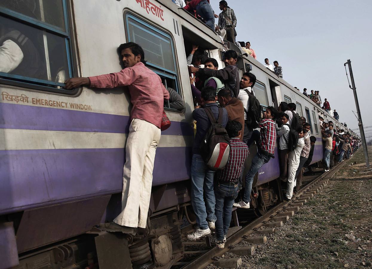 Los pasajeros viajan en un tren abarrotado en las afueras de Nueva Delhi